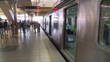 Homem em cadeira de rodas é carregado por passageiros em trilhos do metrô