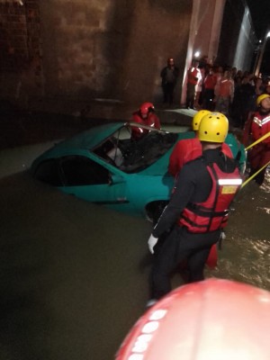um carro foi arrastado com a força das águas, ficando submerso em um córrego com quatro pessoas dentro do veículo