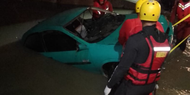 um carro foi arrastado com a força das águas, ficando submerso em um córrego com quatro pessoas dentro do veículo