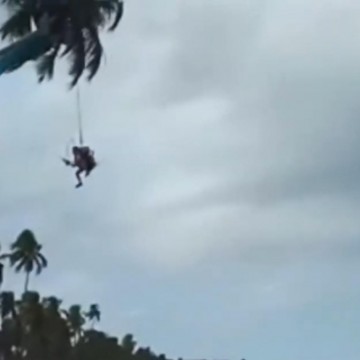 Homem bate em coqueiro com paramotor e fica suspenso a 10 metros de altura em praia no Cabo de Santo Agostinho